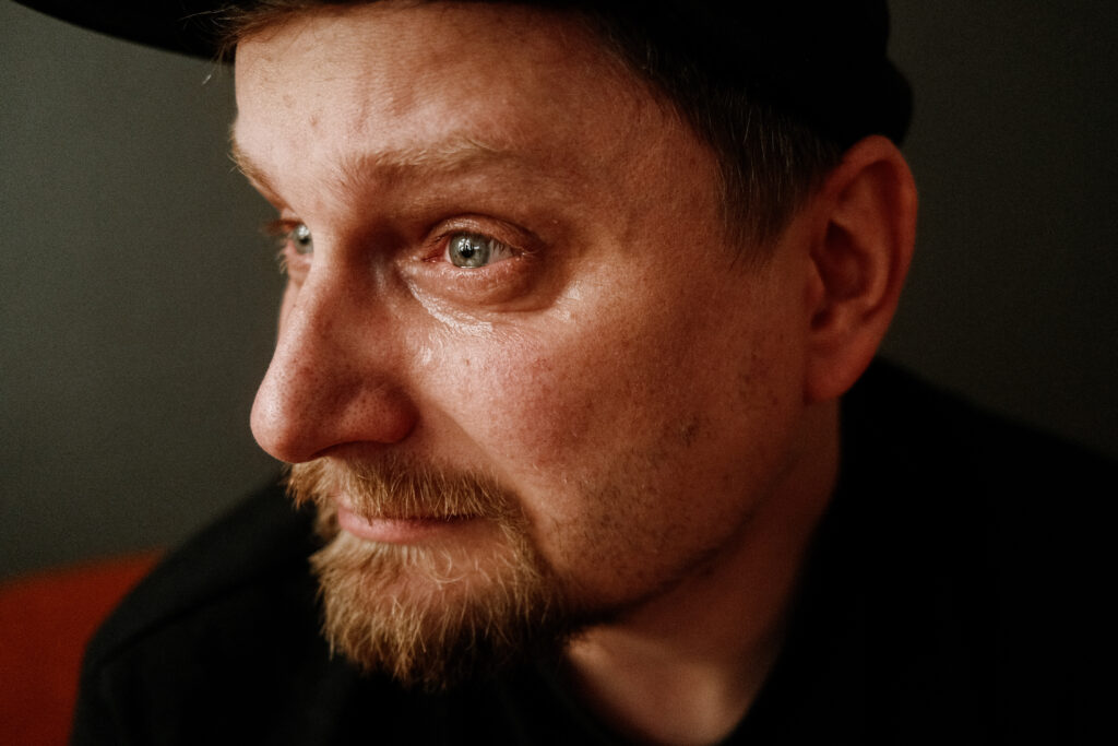 Selbstportrait mit Cap im halben Licht, aufgenommen mit Fuji X100V, Fotograf Martin Neuhof