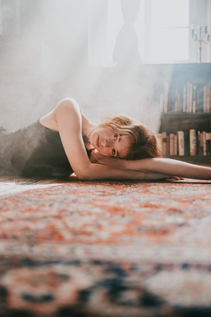 Portrait-Shooting auf dem Teppich im Off The Road Studio Leipzig — Haze und die große Bücherwand im Hintergrund
