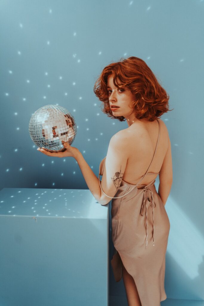 Kreatives Portrait-Shooting im Tageslicht Studio Leipzig — Discokugel-Reflexionen auf blauem Hintergrund, helles natürliches Licht